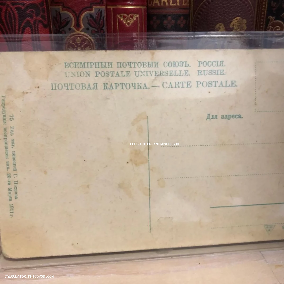 Оборотная сторона чистой антикварной почтовой карточки с надписями на русском и французском языках на фоне старинных книжных переплетов.