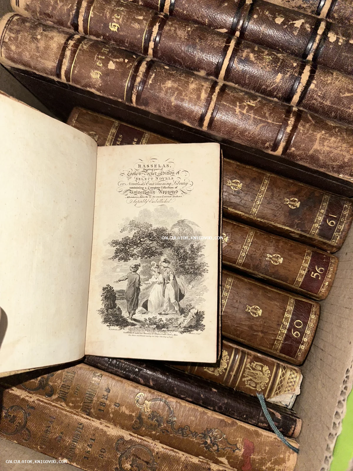 Раскрытая старинная книга с изящной гравюрой на титульном листе в окружении стопки книг в кожаных переплетах с золотым тиснением.