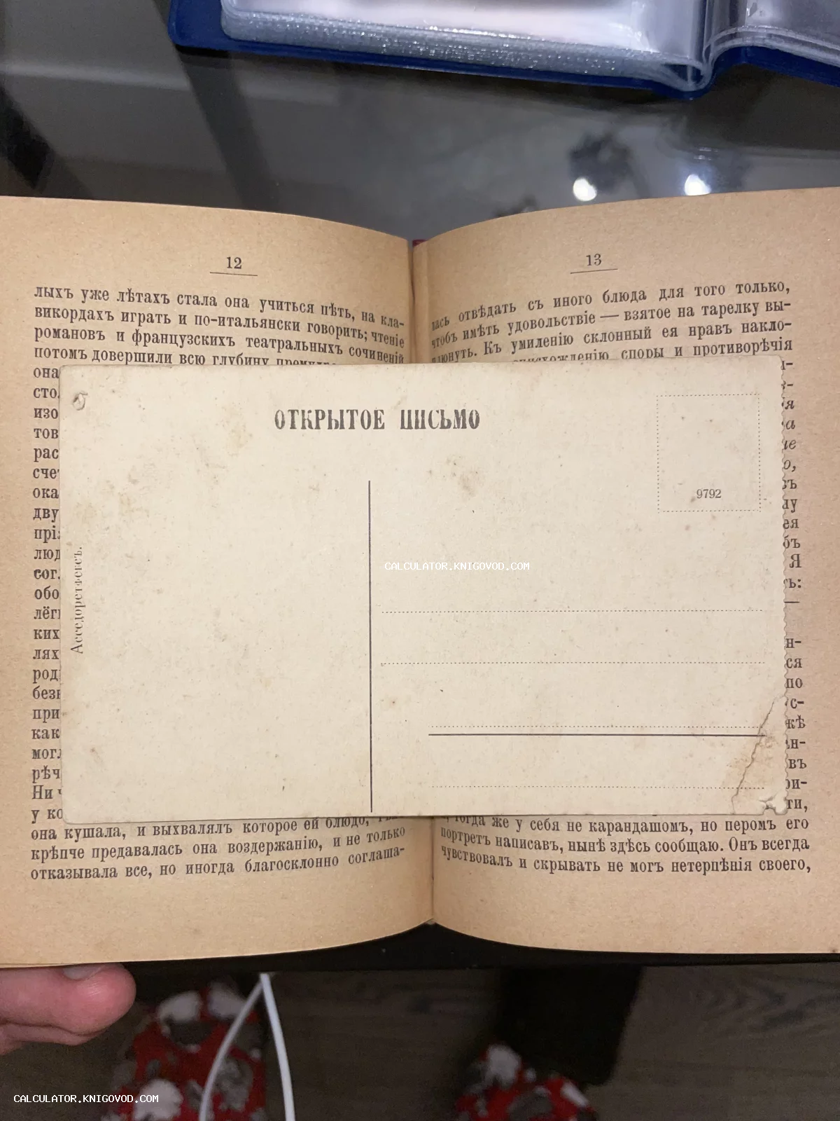Старинный чистый бланк почтовой карточки с надписью 'Открытое письмо' на фоне разворота антикварной книги с дореволюционным шрифтом.