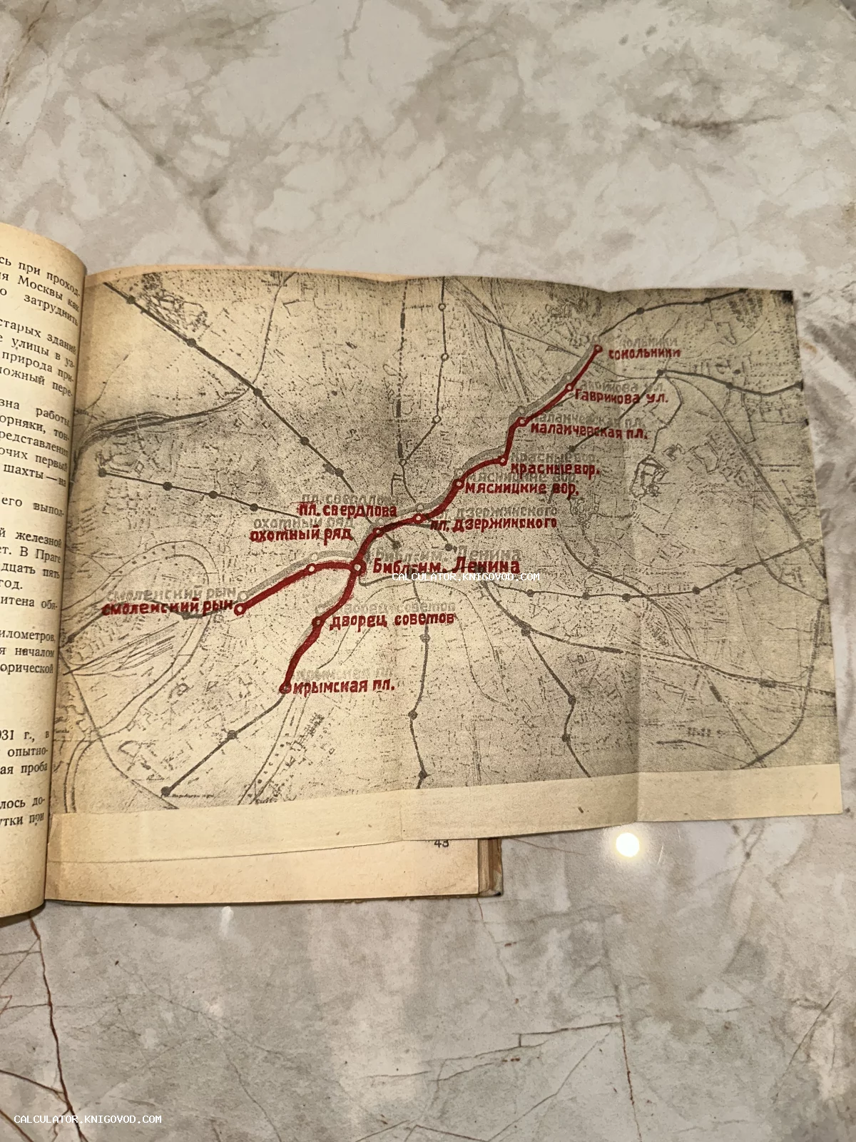 Старинная печатная карта-схема линий Московского метрополитена на развороте книги с указанием первых станций красным цветом.
