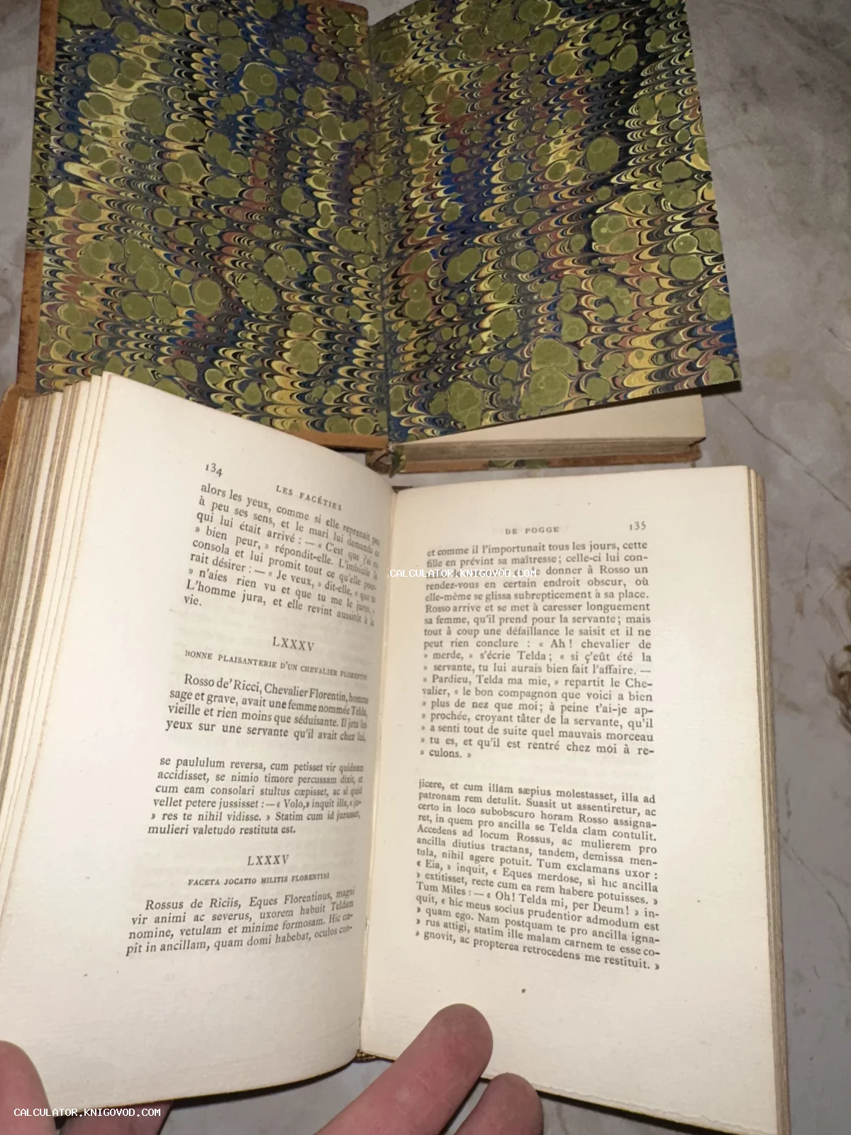 Разворот старинной книги с текстом на французском языке на фоне форзаца с мраморным узором