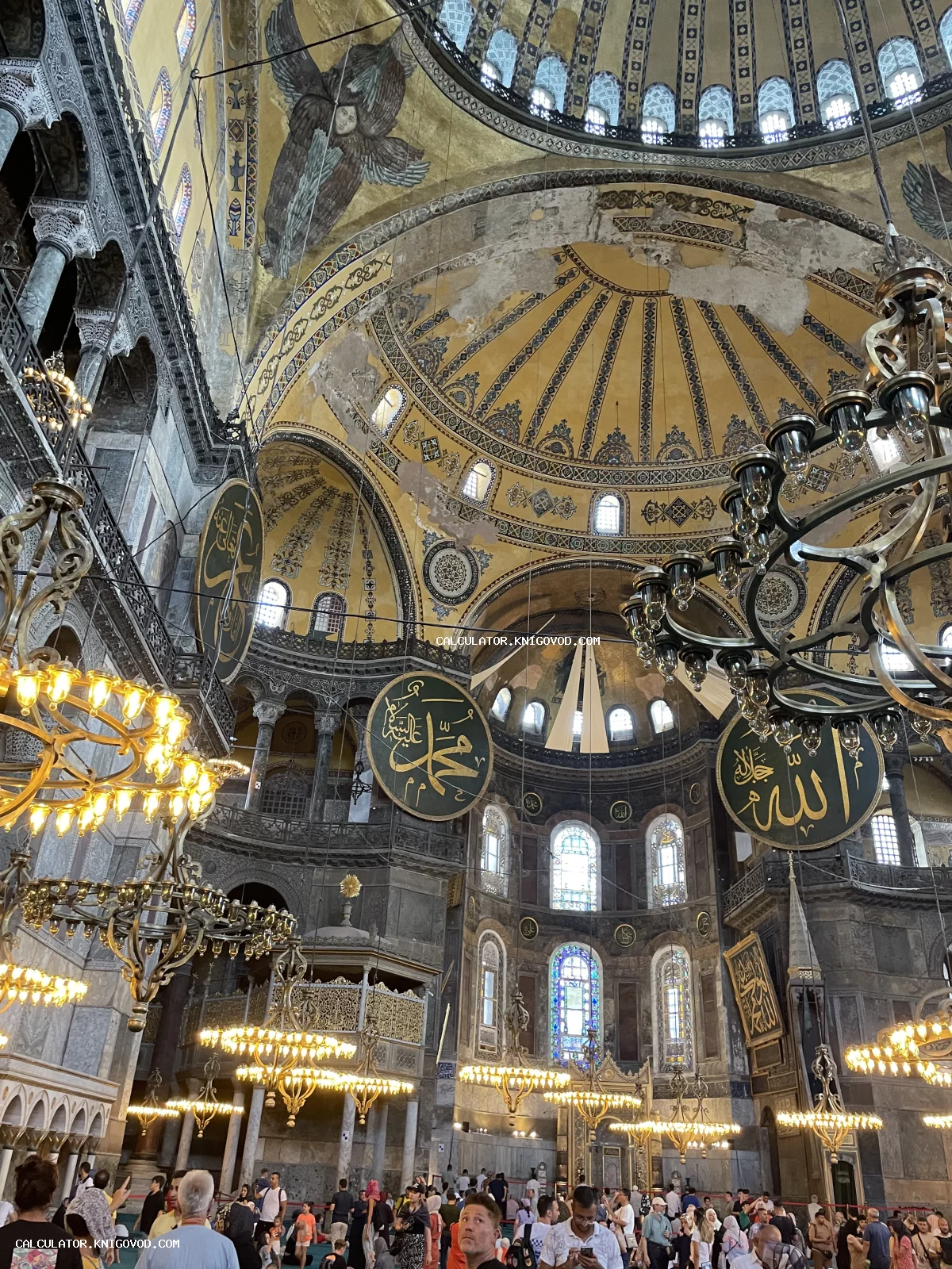Интерьер собора Святой Софии с огромными люстрами, исламскими медальонами и византийскими мозаиками на сводах купола.