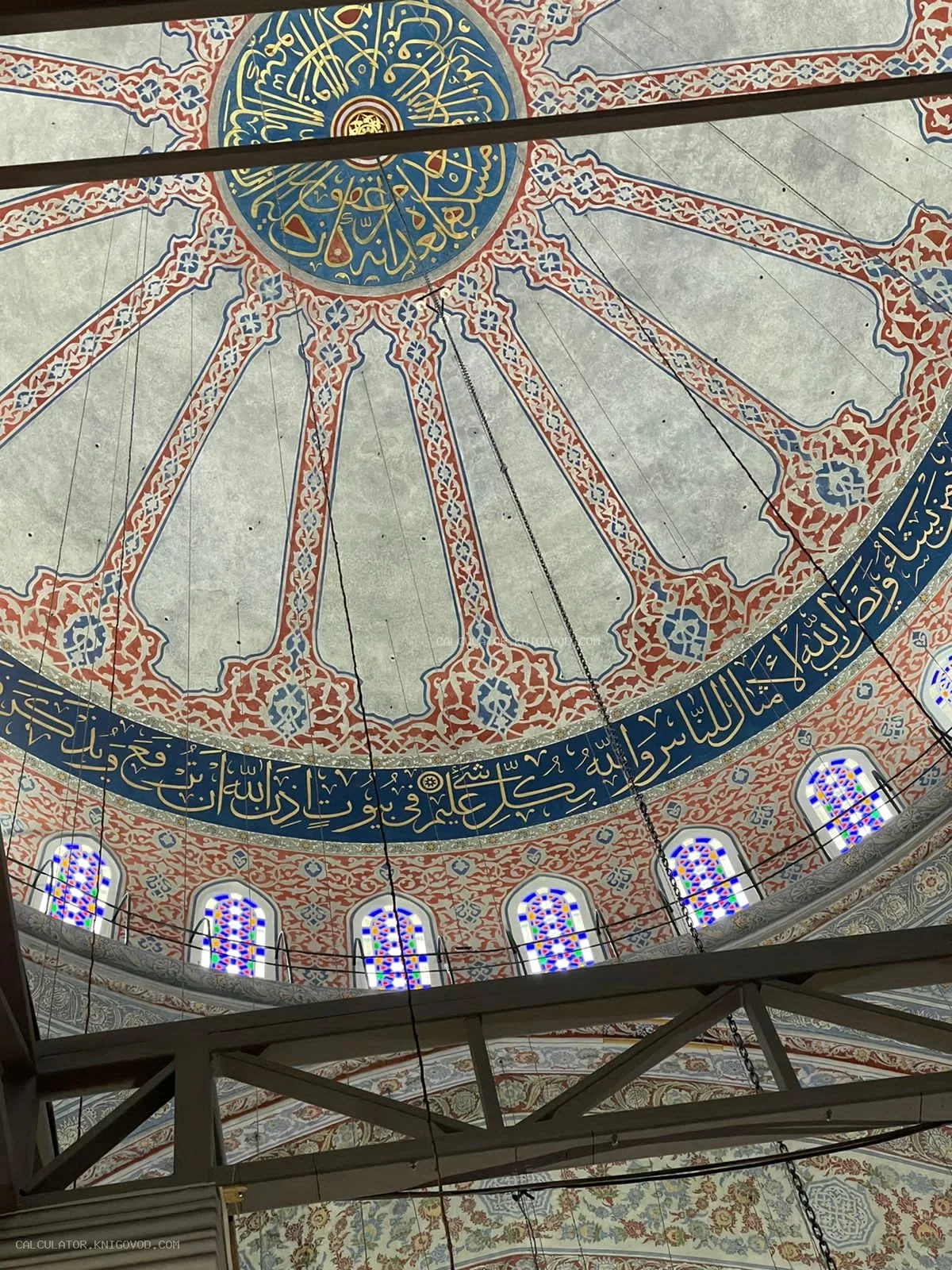 Внутренняя отделка купола мечети с арабской каллиграфией, растительным орнаментом и витражными окнами.