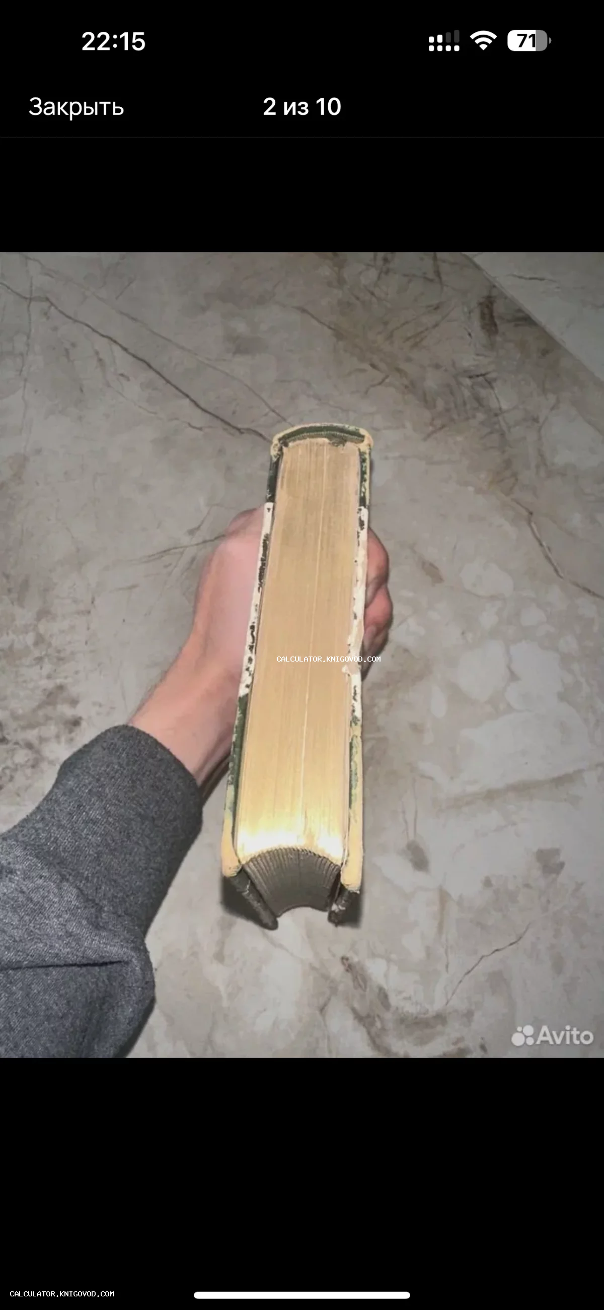 Вид сверху на плотный блок пожелтевших страниц антикварной книги в руке