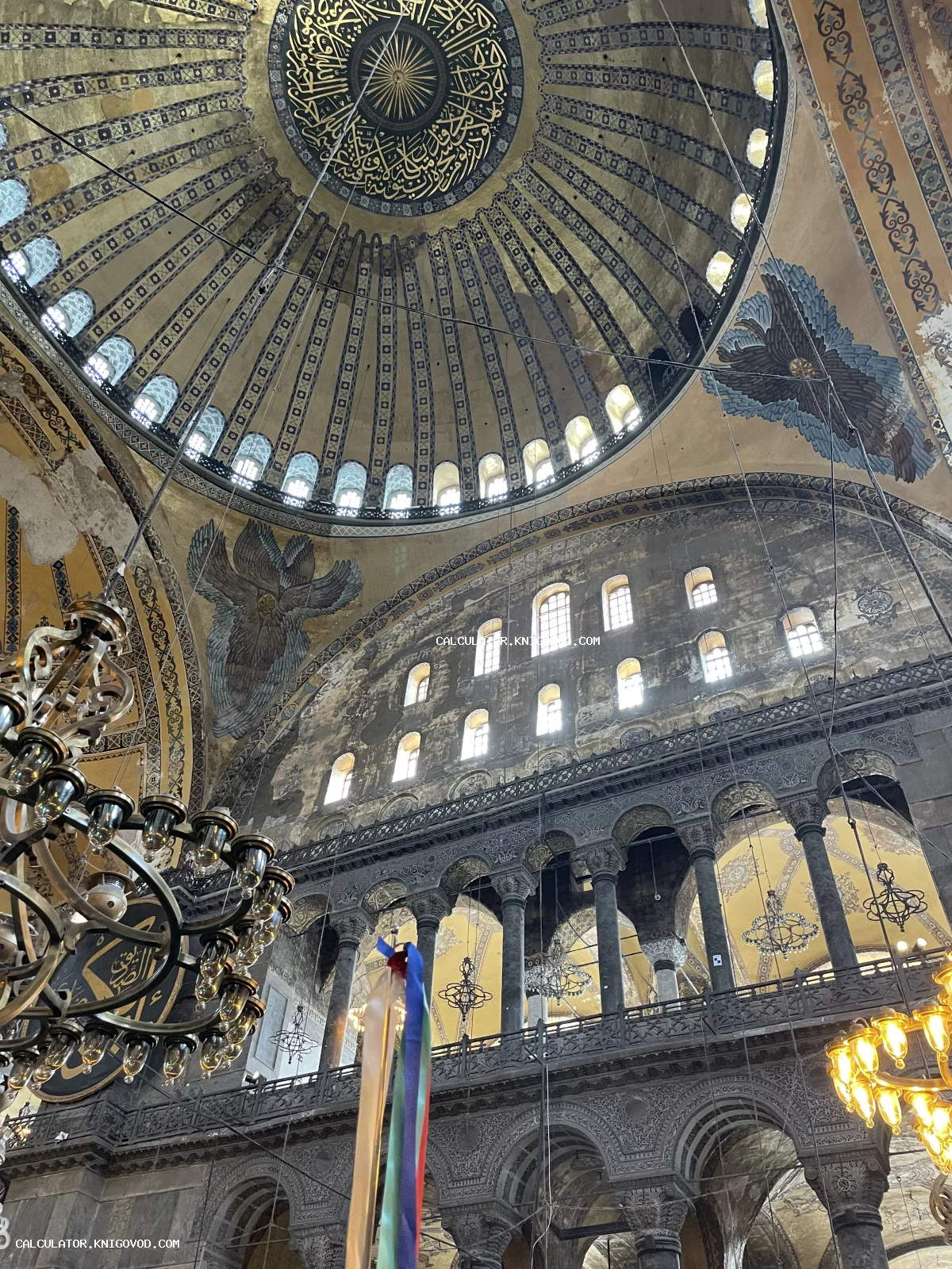 Интерьер собора Святой Софии в Стамбуле: вид на главный купол с арабской вязью, мозаики серафимов и массивные люстры.