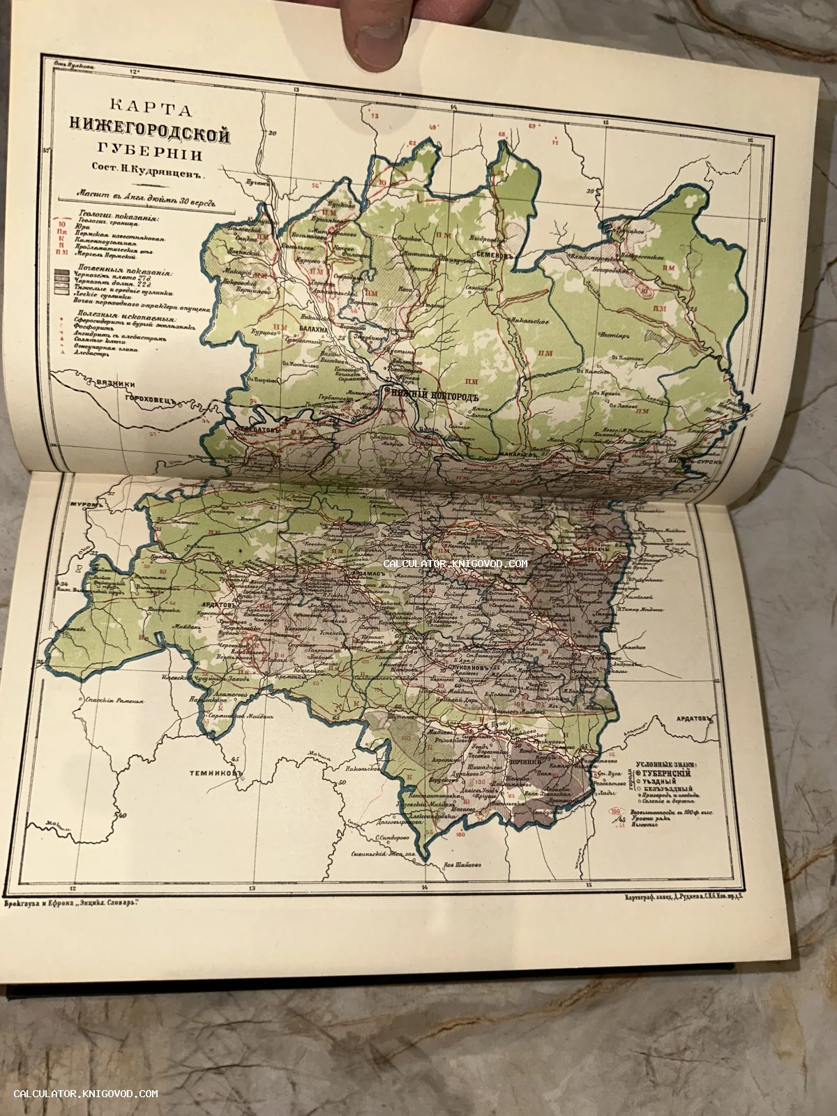 Цветная антикварная карта Нижегородской губернии конца XIX века на развороте книги с подробной легендой и условными обозначениями.