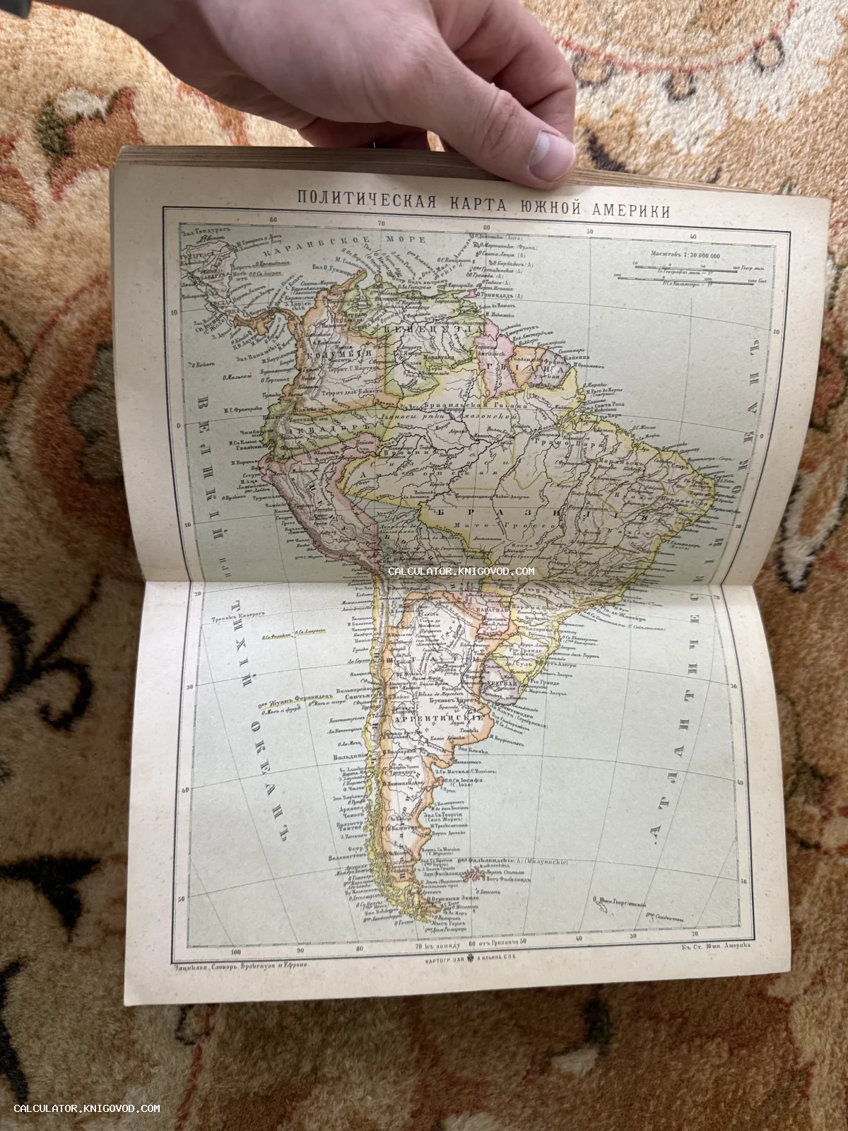 Разворот старинной книги с цветной литографированной политической картой Южной Америки на русском языке.