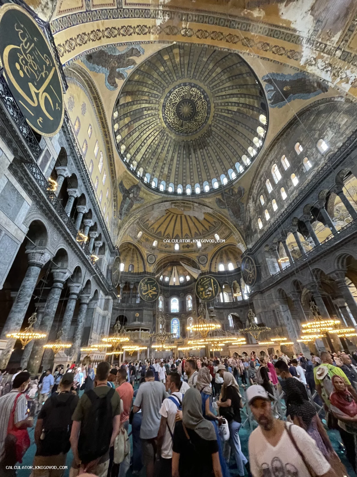 Внутреннее пространство собора Святой Софии в Стамбуле с гигантским куполом, византийскими мозаиками и исламскими каллиграфическими медальонами.