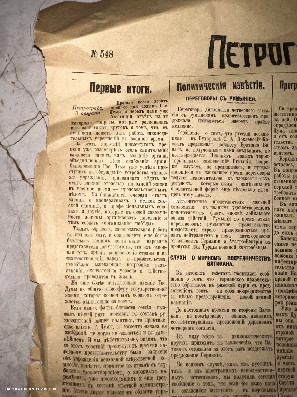 Крупный план пожелтевшей полосы старой газеты с текстом в дореволюционной орфографии и заголовками о политике.