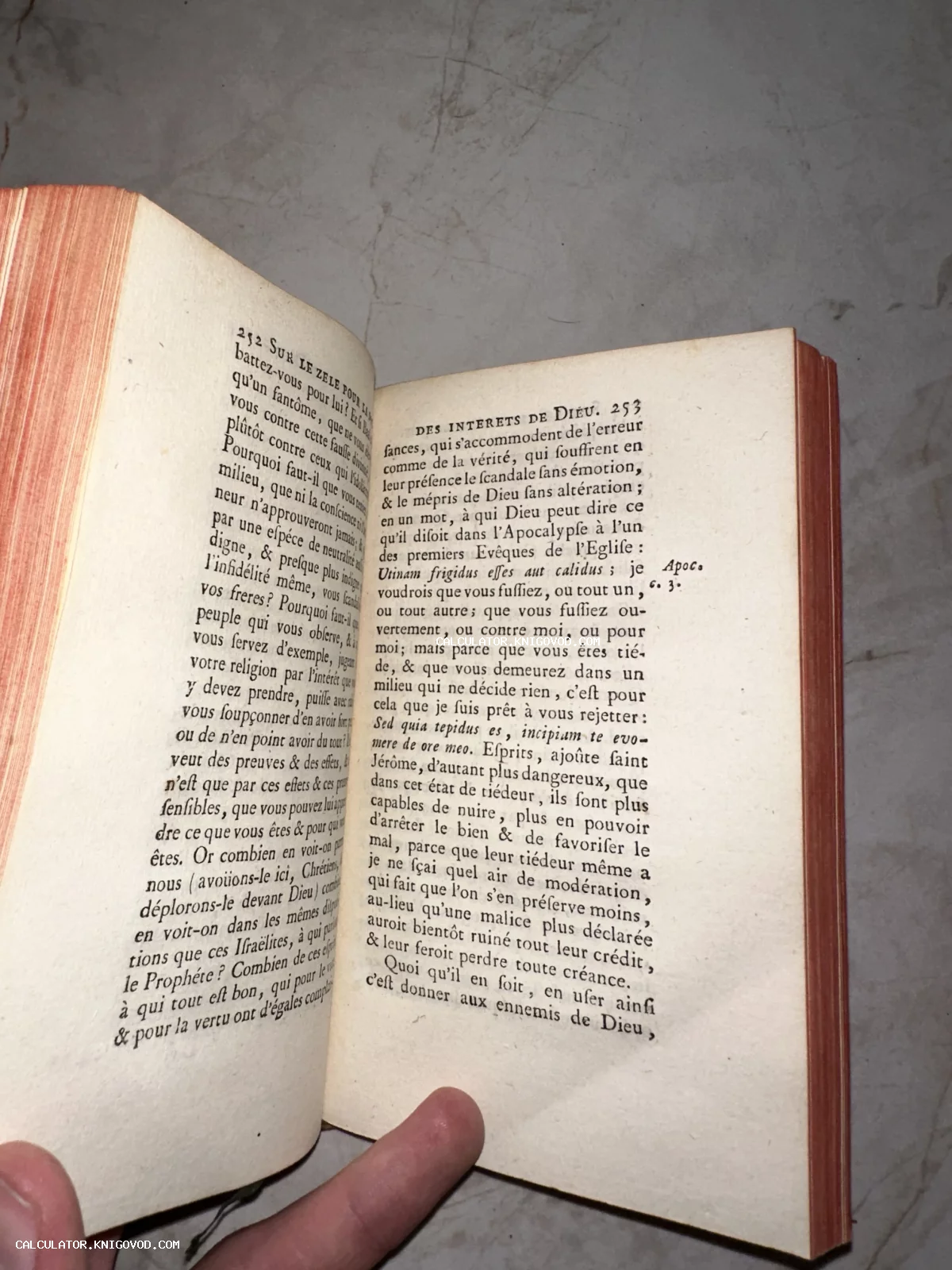 Разворот антикварной книги на французском языке с красным обрезом страниц.