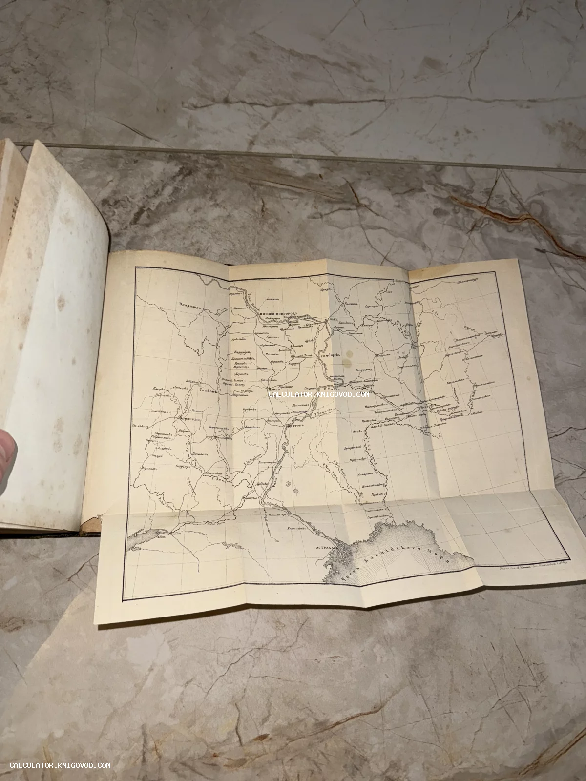 Раскладная географическая карта из старинной книги с изображением течения Волги, Каспийского моря и прилегающих губерний.