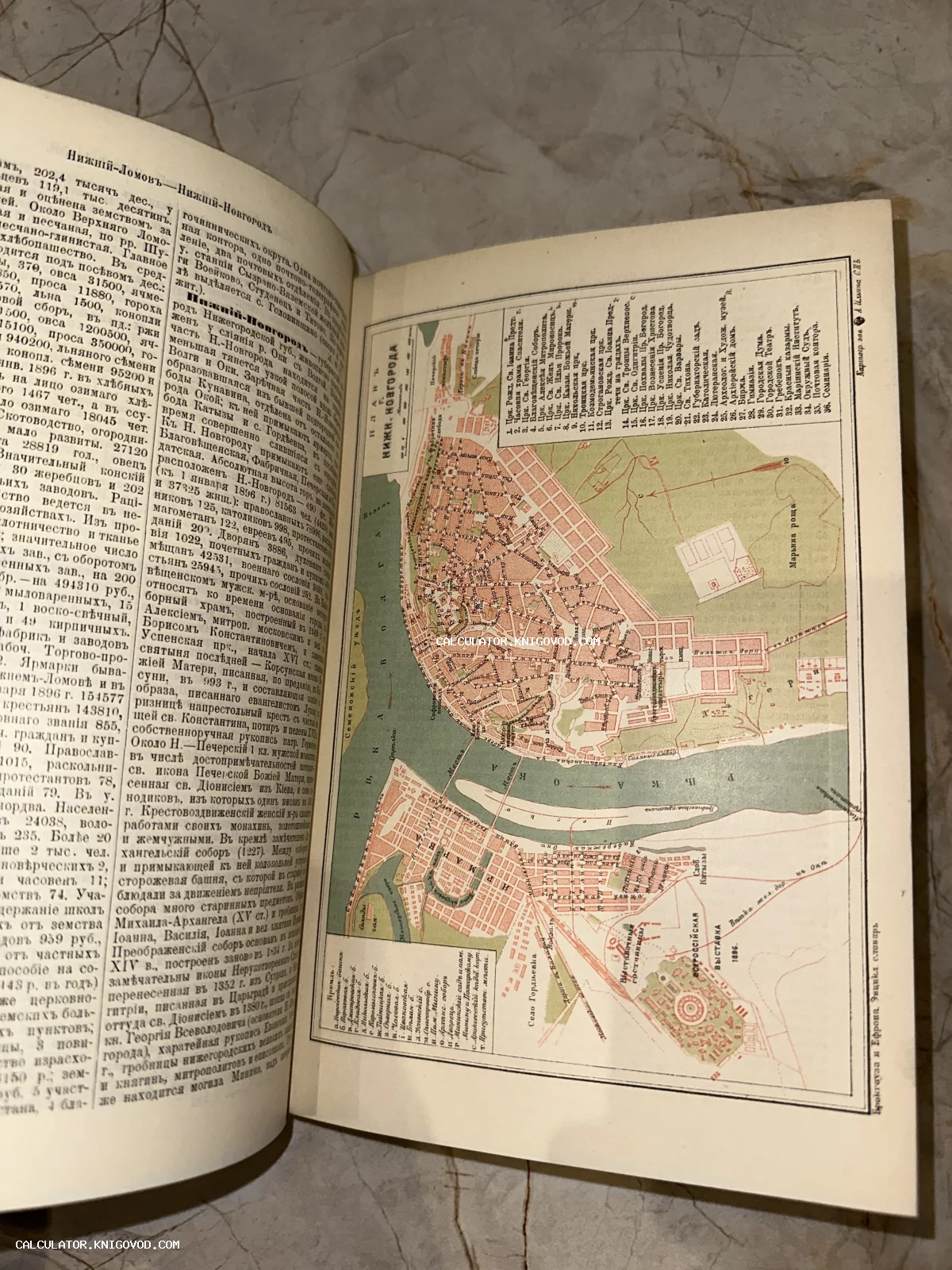 Разворот антикварной книги с цветным планом Нижнего Новгорода и подробным дореволюционным текстом.