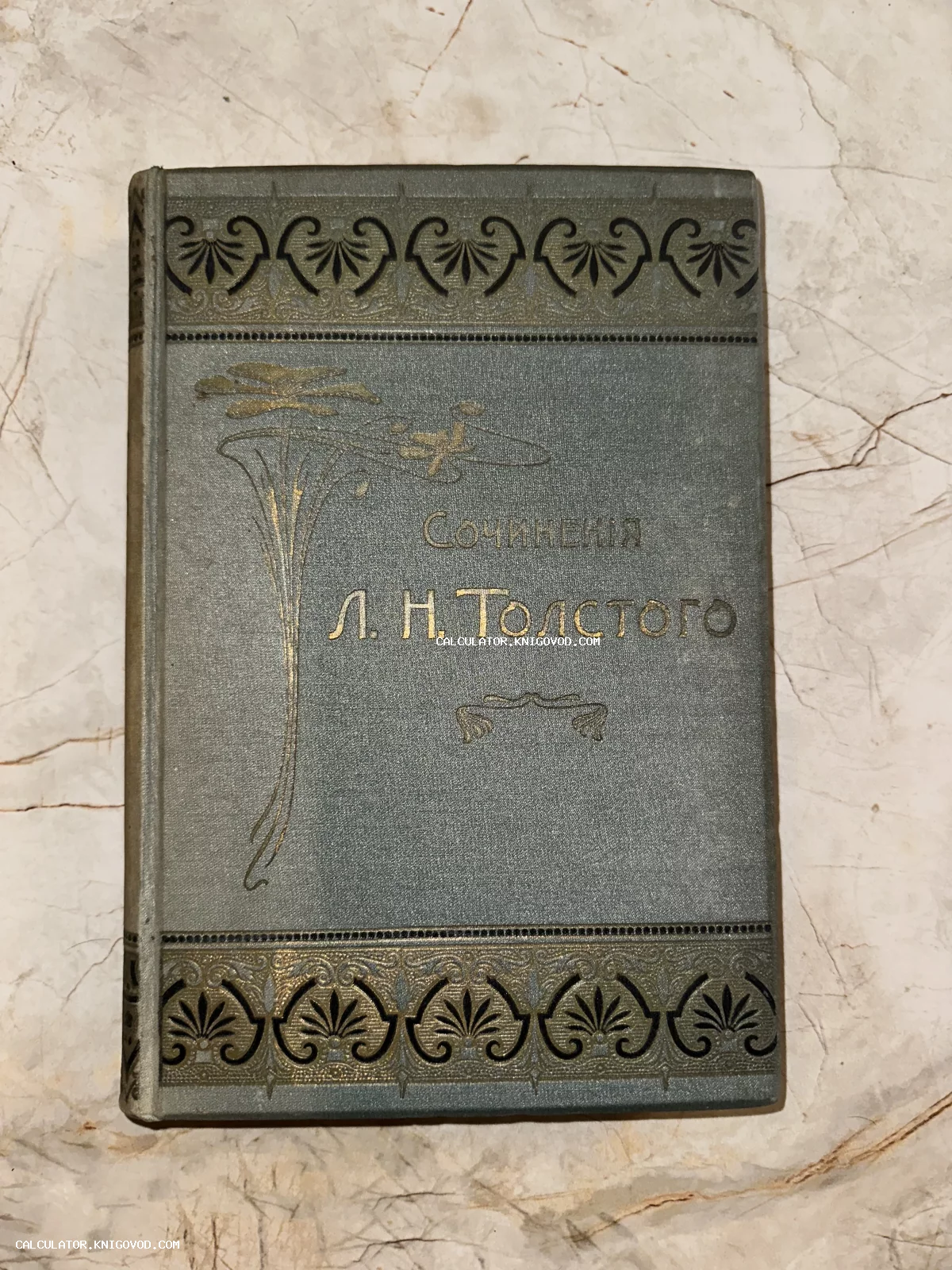 Обложка старинной книги Сочинения Л. Н. Толстого в сером тканевом переплете с золотым и черным тиснением в стиле модерн.