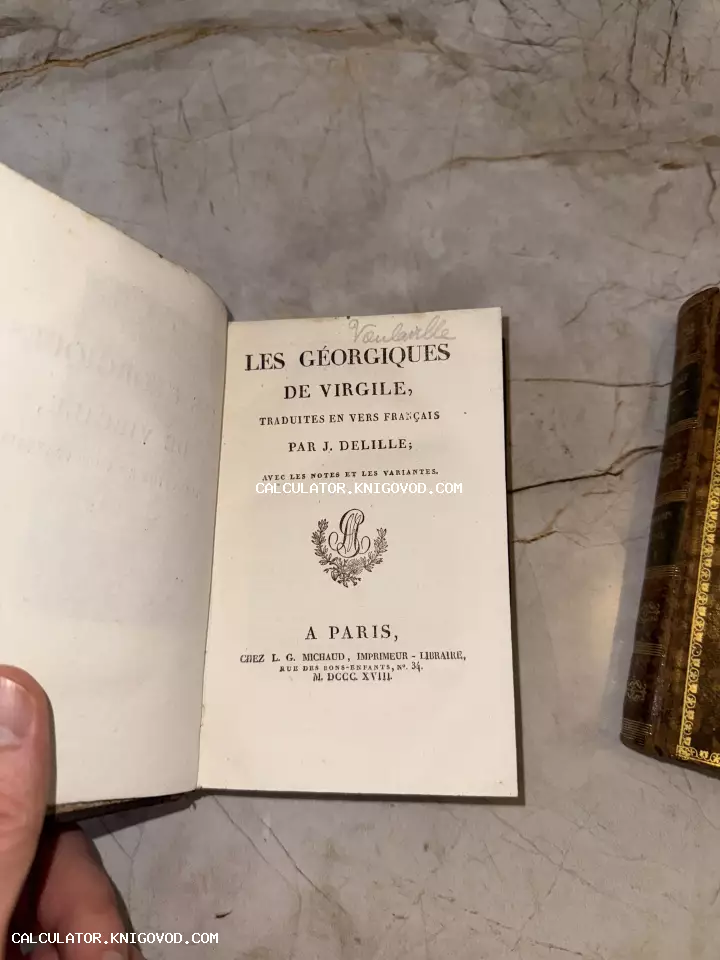 Титульный лист антикварной книги «Les Géorgiques de Virgile» 1818 года издания на фоне мраморной поверхности.