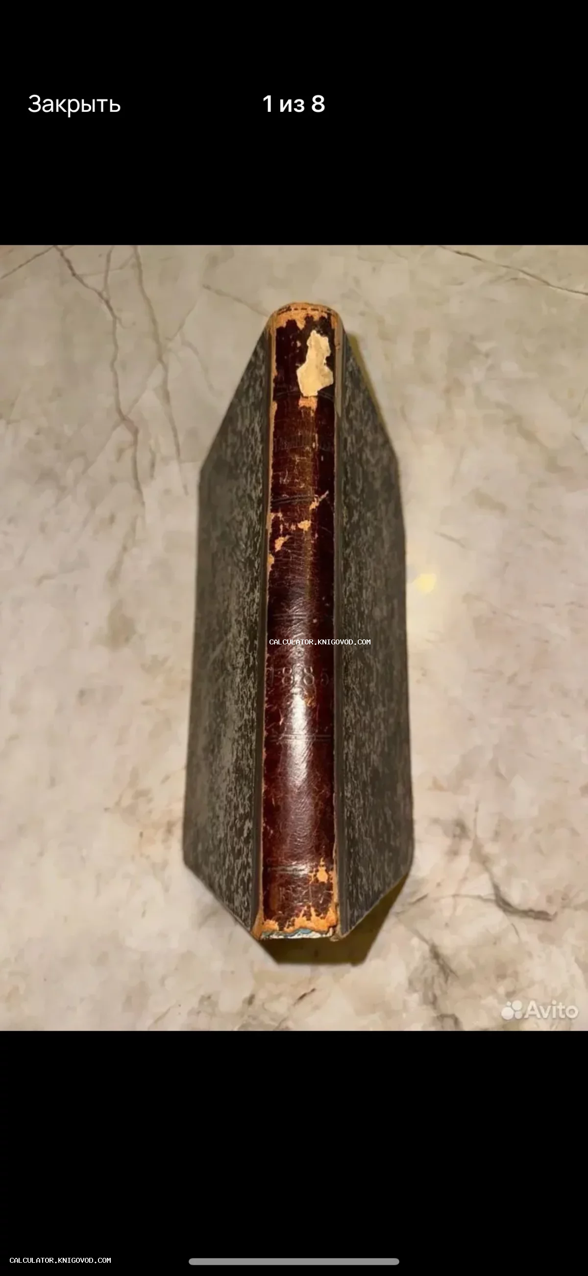 Вид сверху на корешок и обложку старинной книги 1885 года с кожаной отделкой и следами бытования.