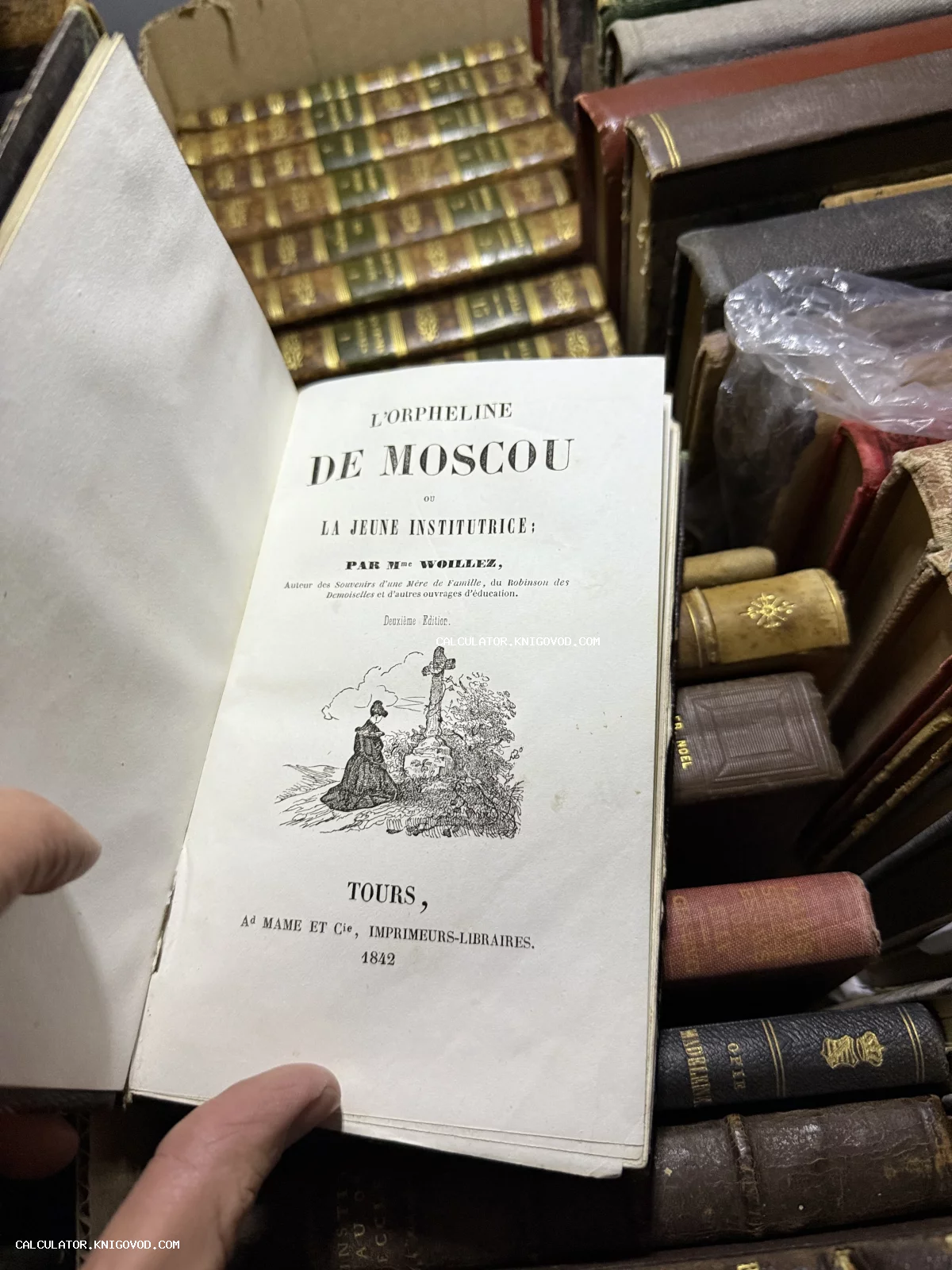 Разворот старинной французской книги L'Orpheline de Moscou с гравюрой на титульном листе в окружении других антикварных томов.