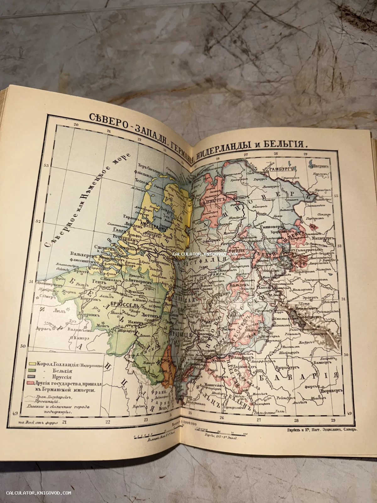 Разворот старинной книги с цветной географической картой Северо-Западной Германии и стран Бенилюкса на русском языке.
