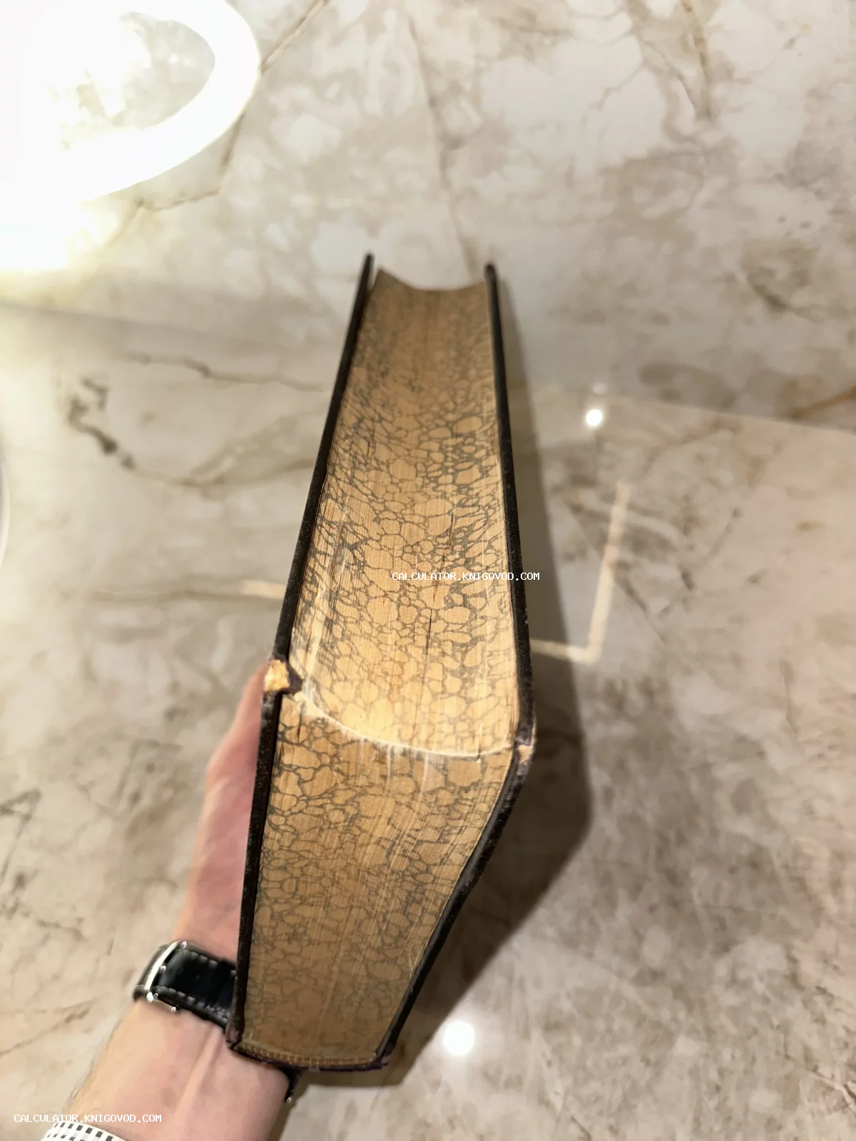 Вид сверху на декоративный мраморный обрез страниц старинной антикварной книги в твердом переплете.