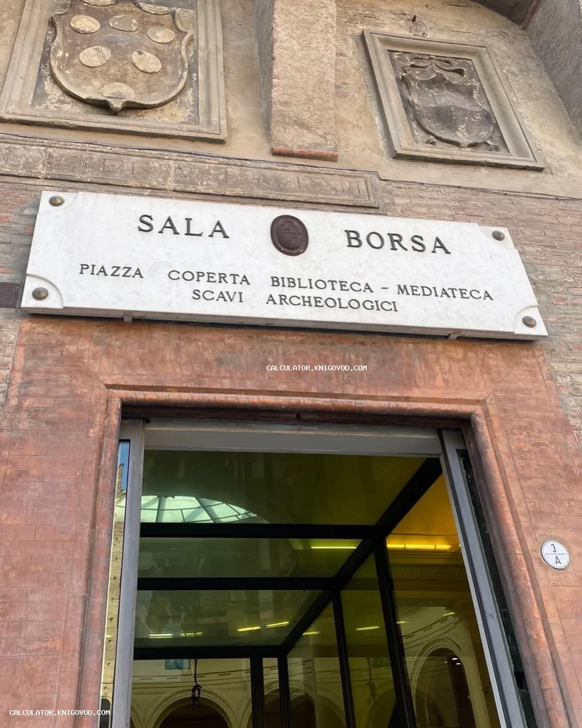 Мраморная вывеска Sala Borsa и старинные фамильные гербы на кирпичной стене исторического здания в Болонье.