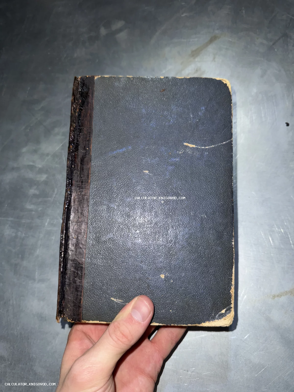Старинная книга в темно-синей обложке с потертыми углами и темным кожаным корешком