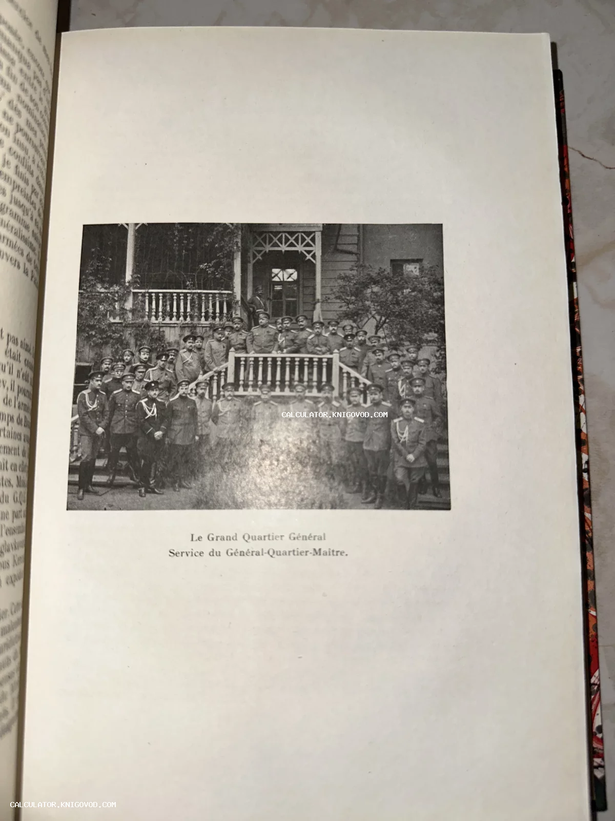 Черно-белая фотография из книги, изображающая большую группу офицеров в военной форме на ступенях деревянного здания штаба.