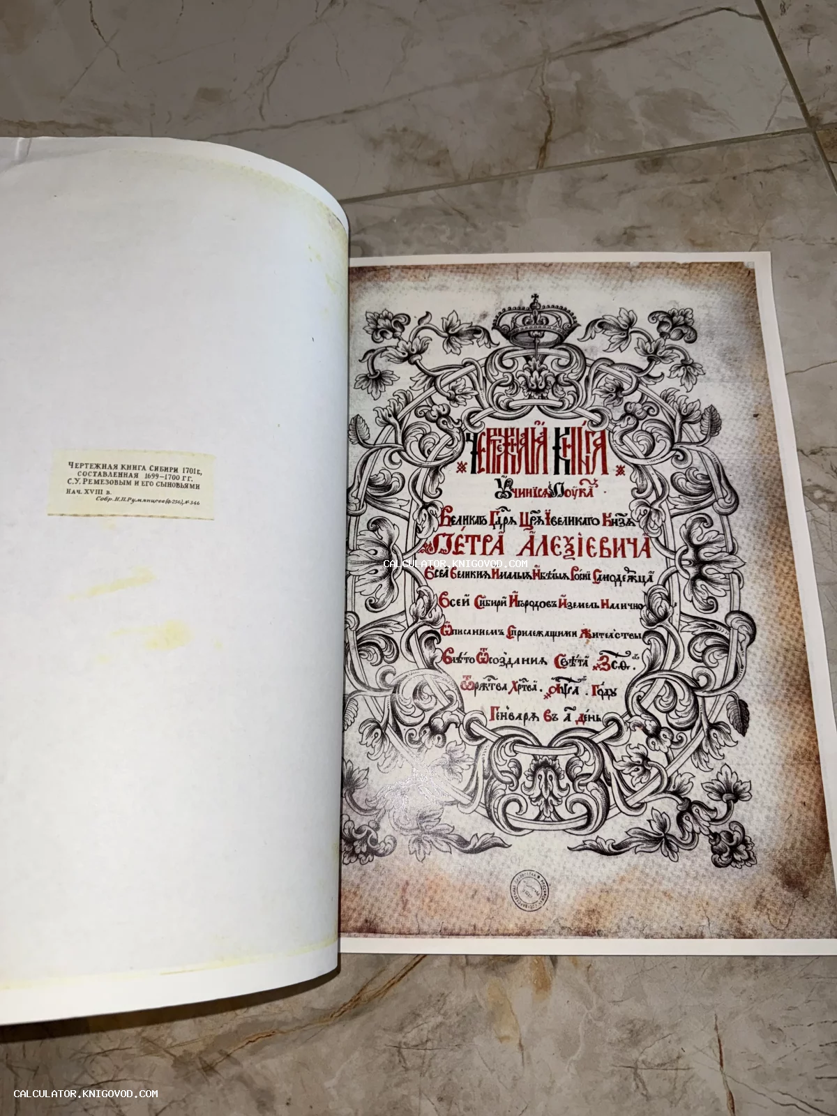 Старинный разворот книги с богато украшенным титульным листом, славянской вязью, короной и растительным орнаментом.