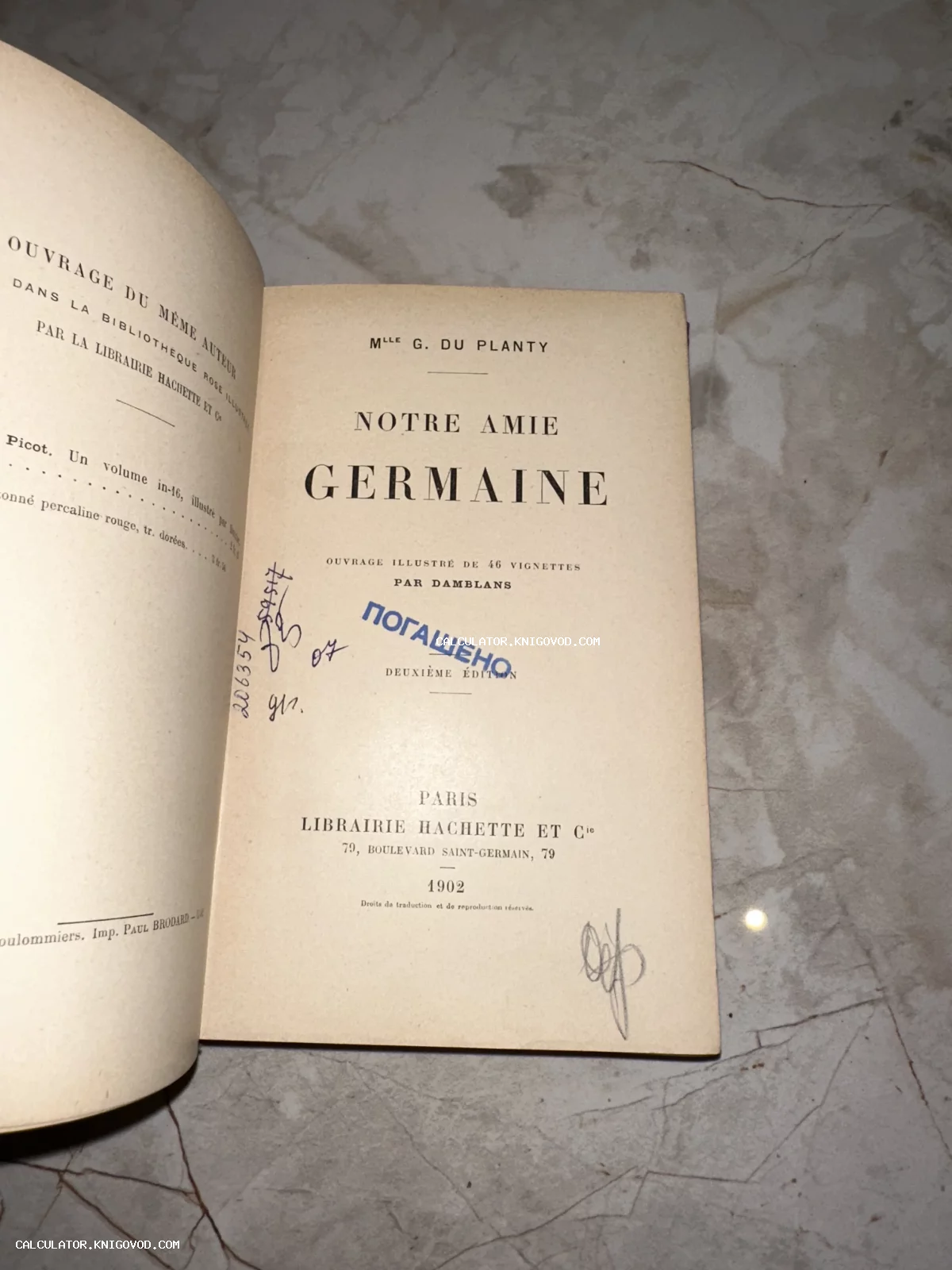 Титульный лист старинной книги 1902 года под названием Notre Amie Germaine издательства Hachette с библиотечными пометками и синим штампом.