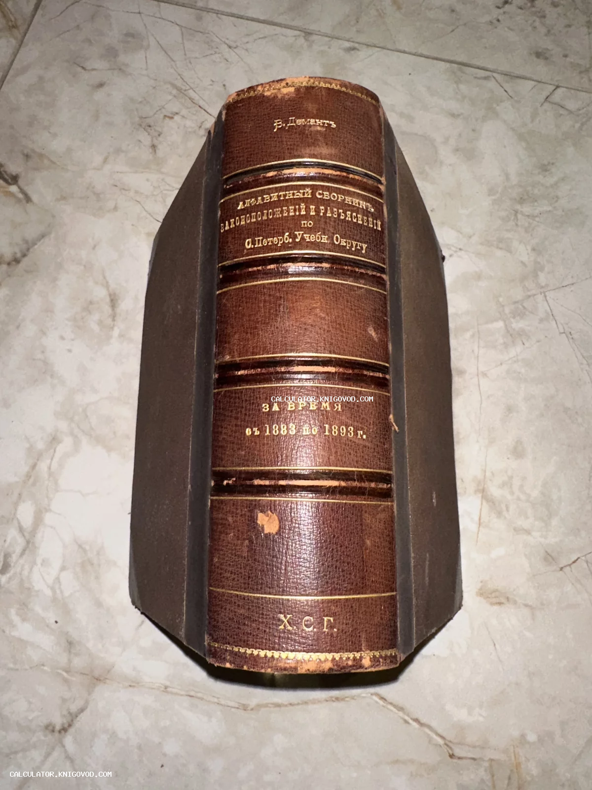 Корешок старинной книги в кожаном переплете с золотым тиснением, за авторством В. Деманта.