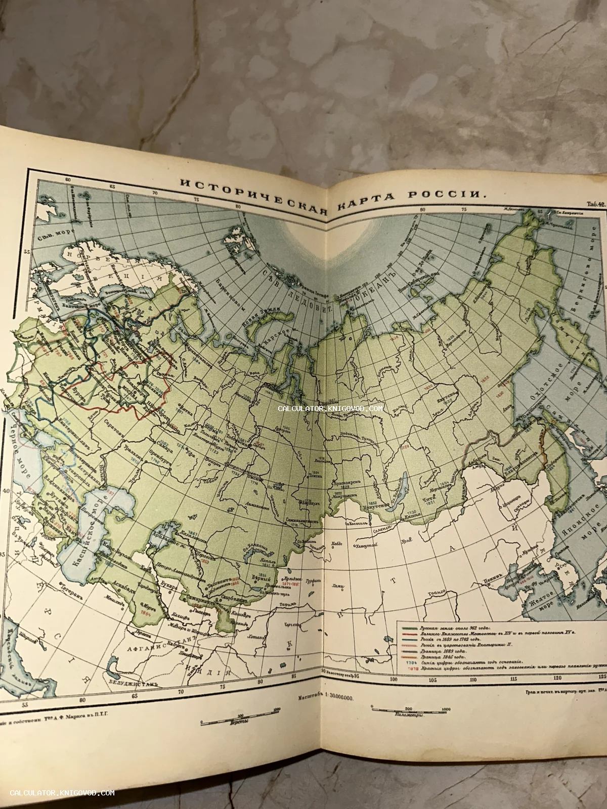 Разворот старинной книги с цветной гравированной картой под названием 'Историческая карта Россіи' с легендой и границами разных эпох.