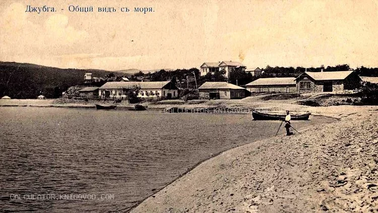 Черно-белое архивное фото поселка Джубга с видом на береговую линию, море, лодки и старинные деревянные дома начала XX века.