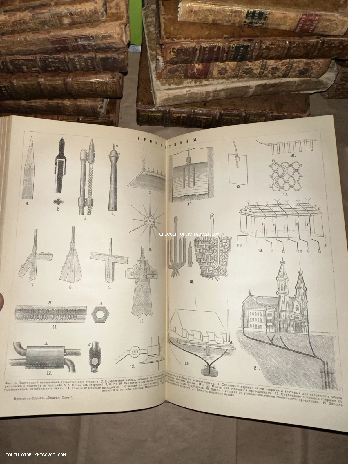 Разворот открытой антикварной книги с чертежами громоотводов на фоне стопки старых томов в кожаных переплетах.