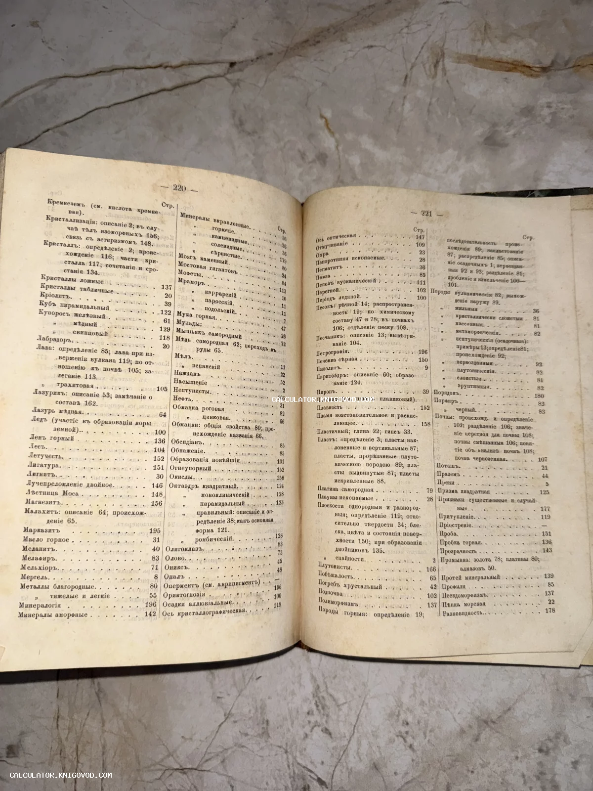 Разворот антикварной книги с алфавитным указателем минералов и геологических терминов на пожелтевшей бумаге.