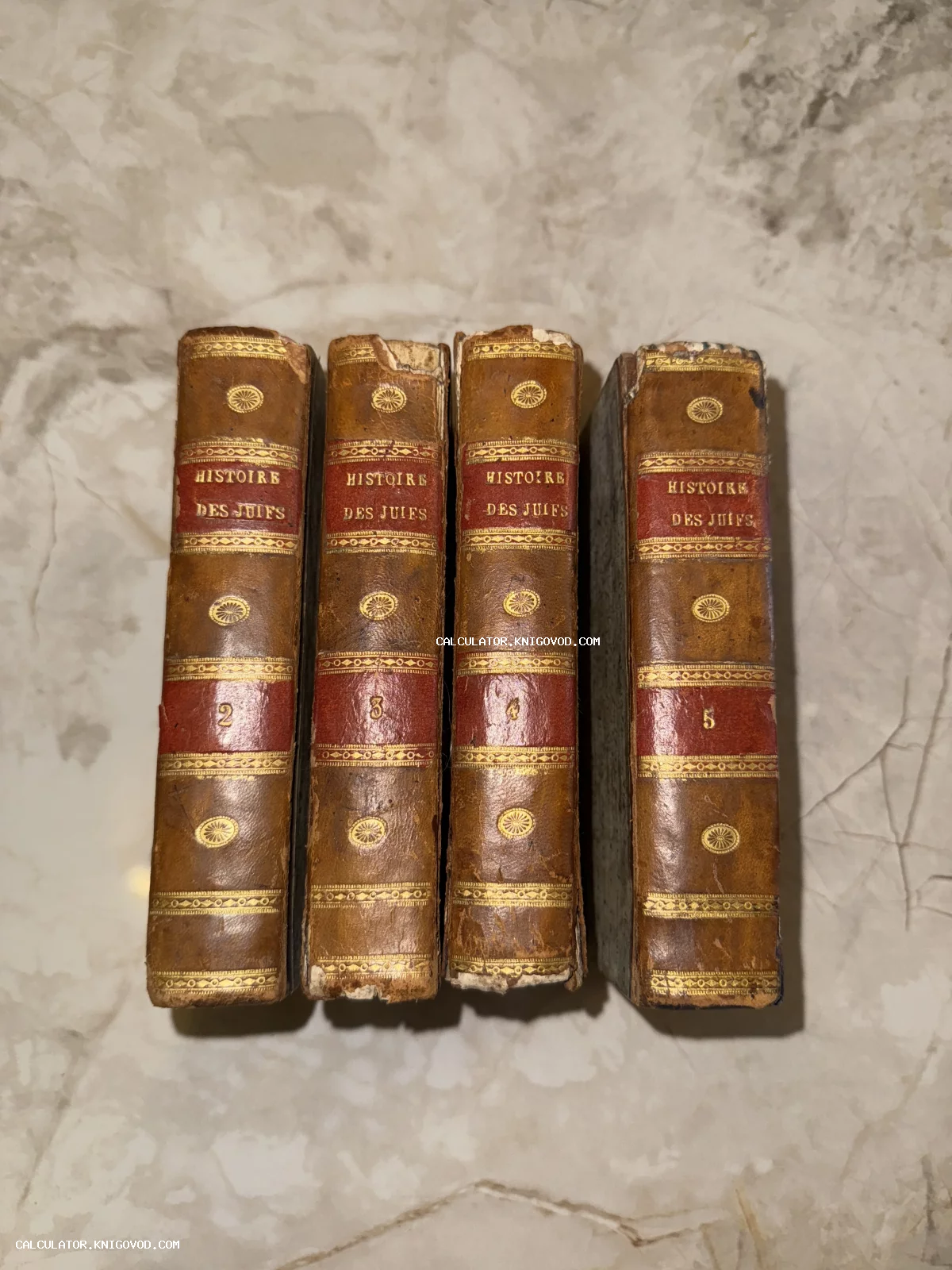 Четыре тома антикварной книги Histoire des Juifs в кожаном переплете с золотым тиснением на корешках.
