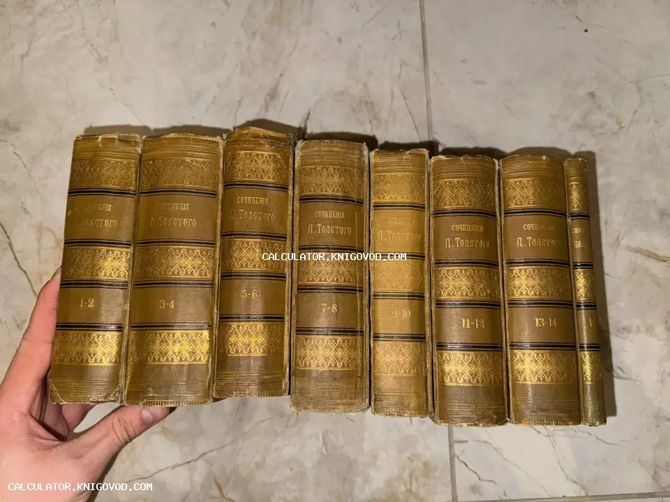 Ряд старинных книг с золотым тиснением на корешках, собрание сочинений Льва Толстого в восьми томах.