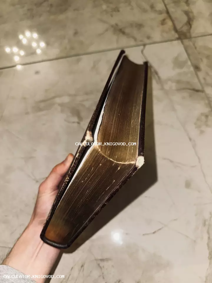 Крупный план старинной книги с позолоченными торцами страниц в руке коллекционера.