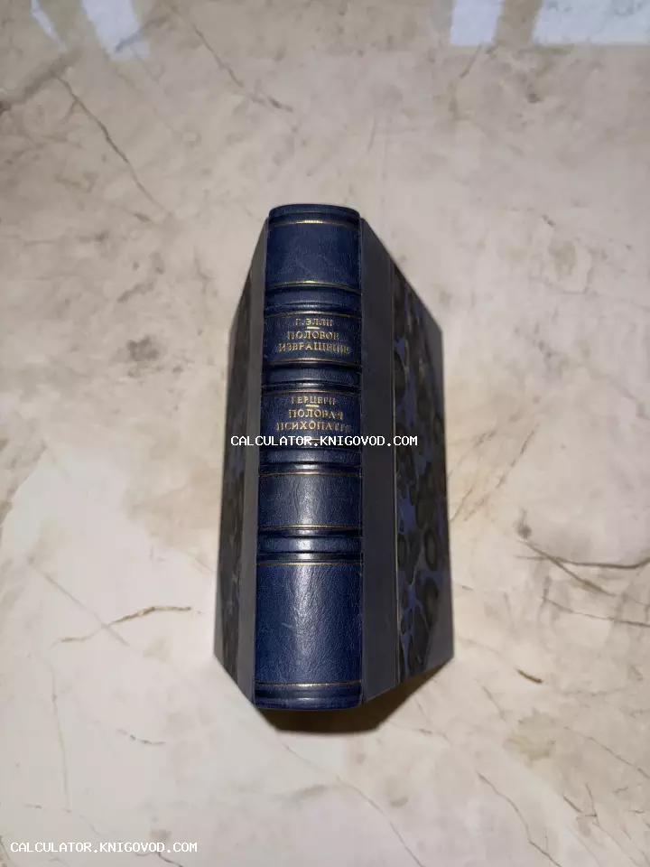 Корешок антикварной книги в темно-синем кожаном переплете с золотым тиснением на фоне мрамора.